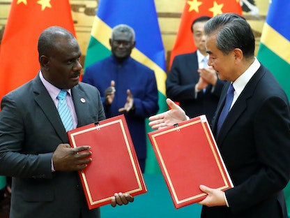 وزير الخارجية الصيني وانج يي ووزير خارجية جزر سليمان جيريمايا مانيلي بعد توقيع اتفاق في بكين - 9 أكتوبر 2019 - REUTERS