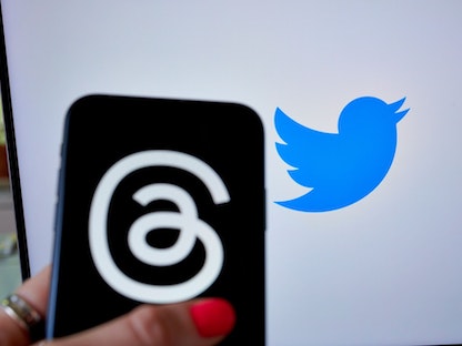 شعار منصة "ثريدز" وخلفه شعار منصة "تويتر" - 13 يوليو 2023 - Bloomberg