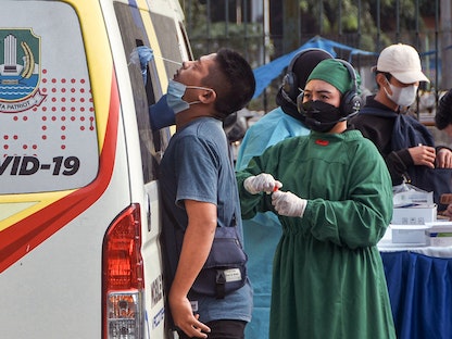 عمال طبيون يجرون اختبارات الكشف عن فيروس كورونا في محطة قطار بالعاصمة الإندونيسية جاكرتا - 2 فبراير 2022 - AFP