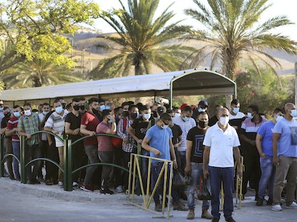 عمال فلسطينيون يستعدون للعبور نحو إسرائيل - AFP