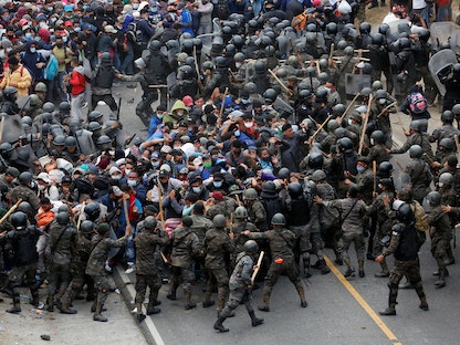 جنود من غواتيمالا يحاولون منع عشرات المهاجرين من هندوراس من العبور إلى الأراضي الغواتيمالية. 17 يناير 2021 - REUTERS