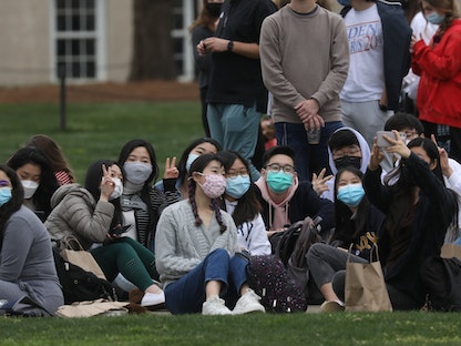 عدد من الطلاب ينتظرون خروج الرئيس جو بايدن بعد اجتماعه مع أعضاء من المجتمع الأميركي الآسيوي في جامعة أتلانتا حول الهجمات الأخيرة- 19 مارس 2021  - REUTERS