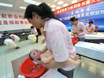 مربيات أطفال يخضعن لتدريب على تحميم الأطفال حديثي الولادة في الصين. 22 مايو 2012 - AFP