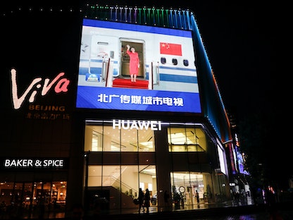 شاشة عملاقة أعلى متجر هواوي في بكين تعرض صورة المديرة المالية لشركة "هواوي" مينج وانتشو بعد إطلاق سراحها - في 26 سبتمبر 2021 - REUTERS