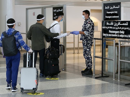 فحص جوازات سفر الركاب في مطار بيروت الدولي في بيروت، لبنان. 1 يوليو 2020. - REUTERS