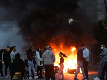 متظاهرون بمدينة صيدا في لبنان، يتجمعون قرب الإطارات المحترقة خلال احتجاج على هبوط الليرة اللبنانية وازدياد الصعوبات الاقتصادية. 8 مارس 2021 - REUTERS