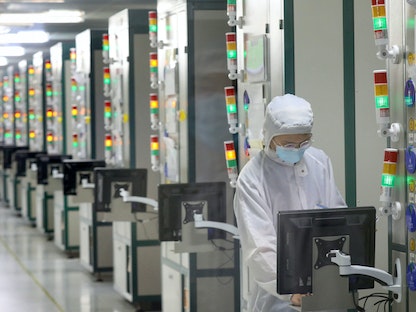 موظف يعمل في مصنع لشركة لتصنيع الرقائق في نانتونج بمقاطعة جيانجسو بشرق الصين. 17 مارس 2021 - AFP
