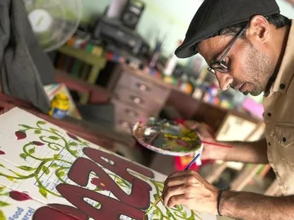 الفنان الفلسطيني أحمد مهنا يرسم على صناديق المساعدات الإنسانية في غزة .(2025) - news.un.org