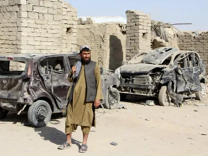 مقاتل من طالبان يقف بجوار مركبات مدمرة جراء غارة جوية خلال الصراع بين أفغانستان وباكستان في منطقة سبين بولداك في ولاية قندهار بأفغانستان. 16 أكتوبر 2025 - Reuters
