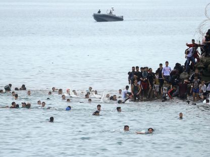 مهاجرون يسبحون وصولاً إلى السياج الفاصل بين المغرب ومدينة سبتة التي تسيطر عليها إسبانيا. 18 مايو 2021 - REUTERS