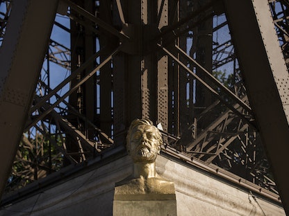 تمثال نصفي لجوستاف إيفل أمام العمود الشمالي لبرج إيفل في باريس في 31 يوليو 2014 - AFP
