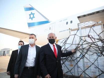 رئيس الوزراء الإسرائيلي بنيامين نتنياهو ووزير الصحة يولي إدلشتاين، خلال وصول طائرة تحمل شحنة من لقاحات فيروس كورونا - 10 يناير 2021 - REUTERS