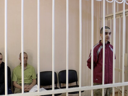 البريطانيان إيدن أسلين وشون بينر والمغربي إبراهيم سعدون خلال محاكمتهم في دونيتسك - 8 يونيو 2022 - REUTERS