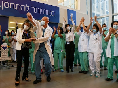 فرق طبية تحتفل قبل تلقي لقاح "فايزر" المضاد لفيروس كورونا في مستشفى "إيخيلوف" مع بداية حملة التطعيم في إسرائيل - 20 ديسمبر 2020 - REUTERS