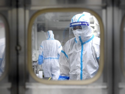 علماء يتعاملون مع عيّنات الحمض النووي داخل مختبر في مدينة ووهان الصينية - VIA REUTERS