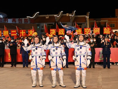 طاقم رحلة الفضاء شنتشو -15 يلوحون خلال احتفال قبل إطلاق المهمة شنتشو -15 في مركز جيوتشيوان لإطلاق الأقمار الاصطناعية شمال غرب الصين- 29 نوفمبر 2022 - AFP
