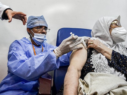 امرأة مسنة تتلقى جرعة من لقاح "سبوتنيك في" في عيادة بمدينة البليدة، جنوب العاصمة الجزائر، 30 يناير 2021 - AFP