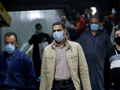 مصريون يرتدون الكمامات لدى توجههم إلى "محطة مترو الشهداء" (رمسيس) بوسط القاهرة - REUTERS