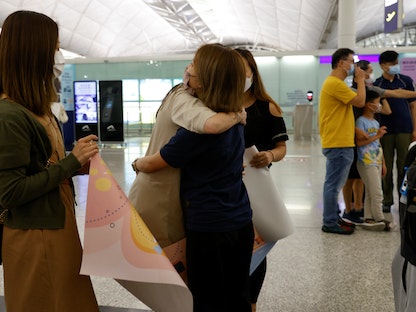 امرأة تعانق صديقتها في مطار هونج كونج الدولي بالصين. 30 يونيو 2021 - REUTERS