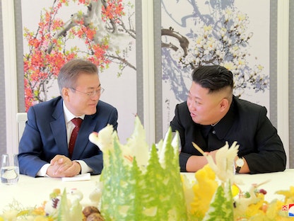 رئيس كوريا الجنوبية مون جاي إن يتحدث إلى زعيم كوريا الشمالية كيم جونغ أون خلال مأدبة غداء -21 سبتمبر 2018  - REUTERS