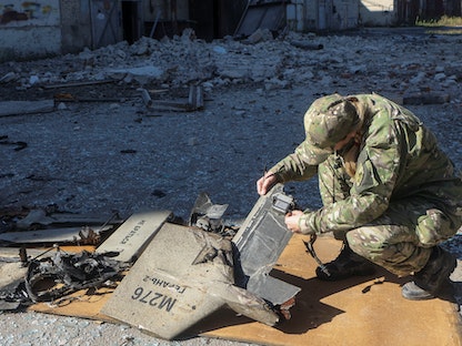 ضابط أوكراني يتفقد أجزاء من مسيّرة قالت كييف إنها إيرانية الصنع من نوع "شاهد-136" في خاركوف، 6 أكتوبر 2022. - REUTERS