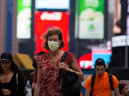 سيدة تضع كمامة وسط مانهاتن في نيويورك. 30 يوليو 2021. - AFP