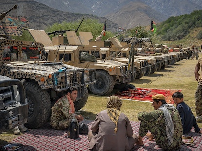 مسلحون أفغان يجلسون بجانب مركبات "هامفي" الأميركية في منطقة باراخ بولاية بنجشير - 19 أغسطس 2021  - AFP