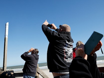 أشخاص يصورون بالون تجسس صيني مشتبه به يحلق قبالة ساحل أحد شوطئ ولاية ساوث كارولينا بالولايات المتحدة- 4 فبراير 2023. - REUTERS