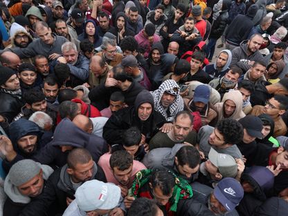 فلسطينيون يتزاحمون للحصول على مساعدات توزعها وكالة الأمم المتحدة لإغاثة وتشغيل اللاجئين الفلسطينيين "الأونروا" في مدينة خان يونس بجنوب قطاع غزة. 27 نوفمبر 2023 - Reuters