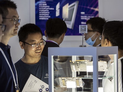 صينيون ينظرون إلى رقائق كمبيوتر وأجهزة عرضت خلال المؤتمر العالمي للذكاء الاصطناعي في شنغهاي - 8 يوليو 2021 - Bloomberg