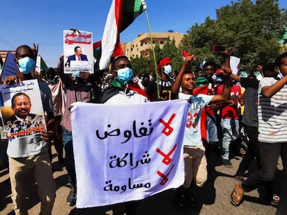 متظاهرون سودانيون يرفعون لافتات تحمل شعار "مليونية 13 نوفمبر" في مظاهرة بالعاصمة الخرطوم  - 13 نوفمبر 2021 - AFP