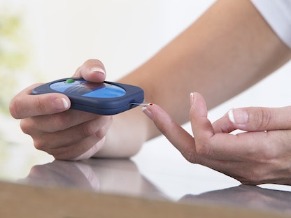 سيدة تجري اختباراً لقياس نسبة السكر في الدم. - Getty Images