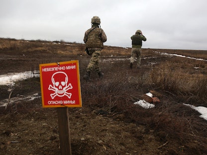جنديان أوكرانيان بالقرب من حقل للألغام في منطقة خط المواجهة مع القوات الموالية لروسيا شرقي أوكرانيا - 11 يناير 2022 - AFP