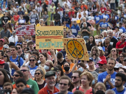 ترفع لافتة كُتب عليها "لتلامذة المدارس الحق في الحياة" خلال مسيرة في واشنطن مناهضة للعنف المسلح بالولايات المتحدة - 11 يونيو 2022 -  AFP