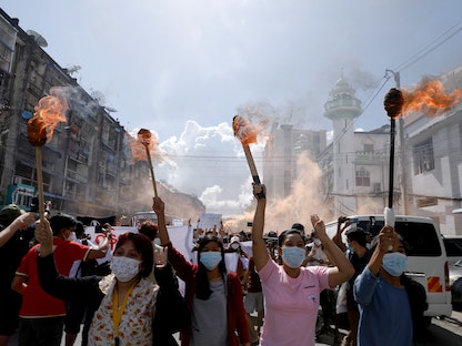 نساء يحملن المشاعل أثناء احتجاجهن على الانقلاب العسكري في ميانمار - 14 يوليو 2021 - REUTERS