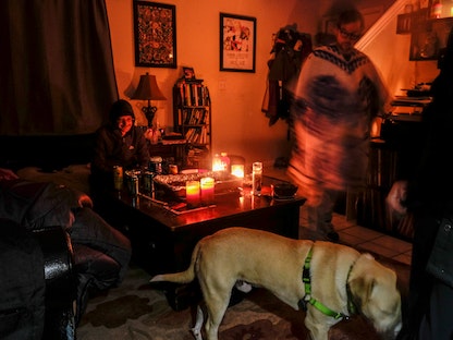 أحد سكان ولاية تكساس الأميركية ينير منزله بالشموع بعد انقطاع التيار الكهربائي - REUTERS