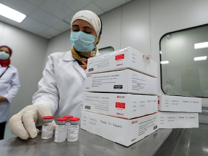 طبيبة مصرية تحمل قوارير لقاح سينوفاك المضاد لكورونا في وحدة الفحص البصري للشركة القابضة للمنتجات البيولوجية واللقاحات (فاكسيرا) في القاهرة، مصر، 31 أغسطس 2021 - REUTERS