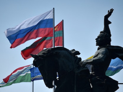 علما روسيا وجمهورية ترانسنيستريا الانفصالية يرفرفان بالقرب من تمثال للقائد العسكري الروسي ألكسندر سوفوروف، في تيراسبول 12 سبتمبر 2021   - AFP