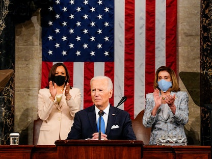 الرئيس الأميركي جو بايدن يلقي كلمته أمام جلسة مشتركة للكونغرس، بينما تصفق نائبته كامالا هاريس ورئيسة مجلس النواب نانسي بيلوسي. 28 أبريل 2021 - REUTERS
