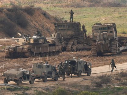 آليات عسكرية إسرائيلية وجنود على حدود غزة مع استمرار القصف الجوي المدفعي على القطاع. 14 يناير 2024 - Reuters