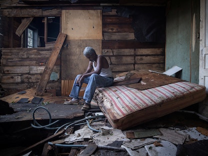 مسن أميركي يجلس داخل منزله الذي تضرر بشدة من إعصار أيدا في لويزيانا - 30 أغسطس 2021 - REUTERS