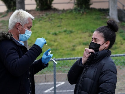 رد فعل امرأة بعد خضوعها لمسحة أنف اختبار فيروس كورونا (COVID-19) خلال موسم الأعياد حيث يهدد متغير أوميكرون بزيادة عدد الحالات، ولاية كاليفورنيا الأميركية - 22 ديسمبر 2021 - REUTERS
