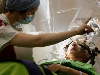 جراح أعصاب يتحدث مع مريض يخضع لعملية جراحية في الدماغ في المعهد الوطني لطب الأعصاب في بودابست. 15 ديسمبر 2012 - REUTERS