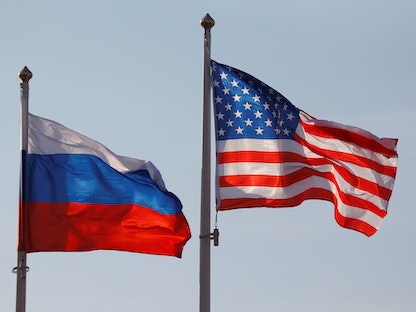 العلمان الأميركي والروسي في مطار بالعاصمة موسكو- 11 أبريل 2017 - REUTERS