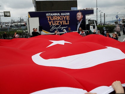 أنصار الرئيس التركي رجب طيب أردوغان في إسطنبول يحملون علم تركيا بنقطة انطلاق حملته الانتخابية قبل جولة الإعادة. 20 مايو 2023 - REUTERS