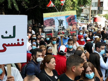 متظاهرون يرفعون لافتات تندد بتعليق التحقيق في انفجار مرفأ بيروت، لبنان، 29 سبتمبر 2021  - REUTERS