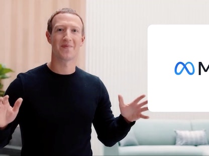 الرئيس التنفيذي لشركة فيسبوك مارك زوكربيرج خلال إعلان الاسم الجديد وبجانبه شعار "ميتا"- 28 أكتوبر 2021 - REUTERS