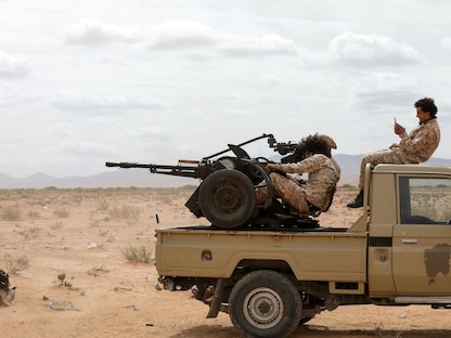 عناصر من حرس المنشآت النفطية في ليبيا يستقلون شاحنة صغيرة في بلدة بئر الغنم جنوب غربي طرابلس- 22 مارس 2021  - REUTERS