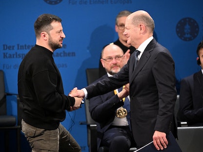 المستشار الألماني أولاف شولتز يصافح الرئيس الأوكراني فولوديمير زيلنيسكي خلال تسليمه جائزة شارلامين، ألمانيا. 14 مايو 2023 - via REUTERS