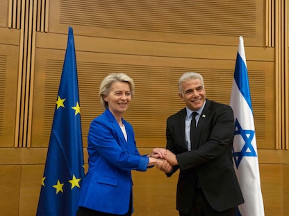 رئيسة المفوضية الأوروبية أورسولا فون ديرلاين تصافح وزير الخارجية الإسرائيلي يائير لبيد في القدس. 13 يونيو 2022 - AFP